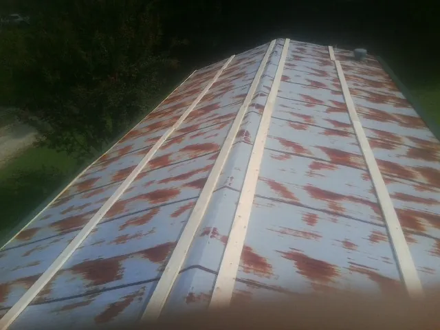 Rusted metal roof panels with new wood purlins before replacement — Storm Damage Roof Repair in Blakesburg by Roofing Brothers