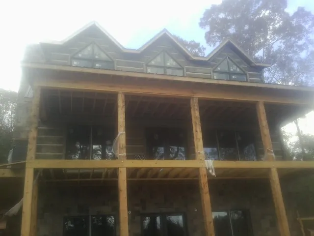Dormers and porch framing on a large log home under construction — Roof Coating work by our crew in Blakesburg