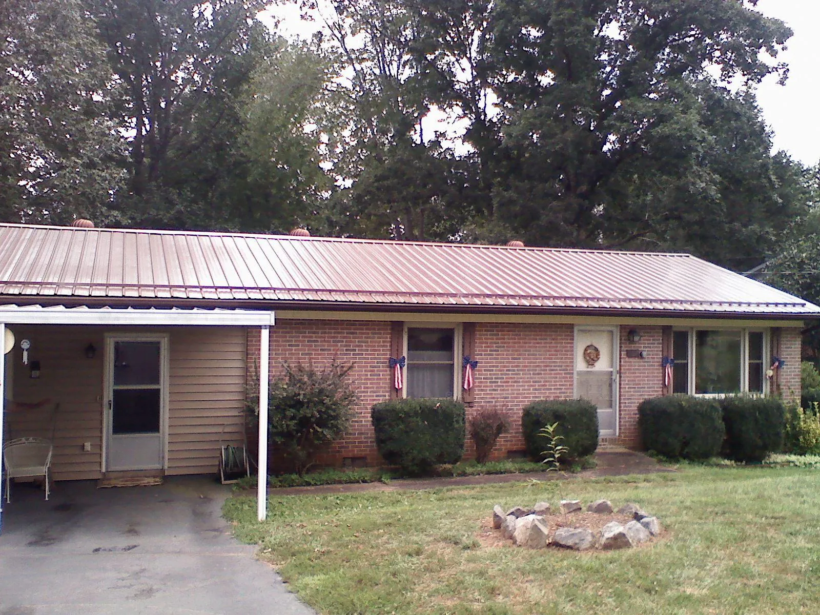 Bronze metal roof and carport on a brick ranch home — Roof Repair work by our crew in Blakesburg